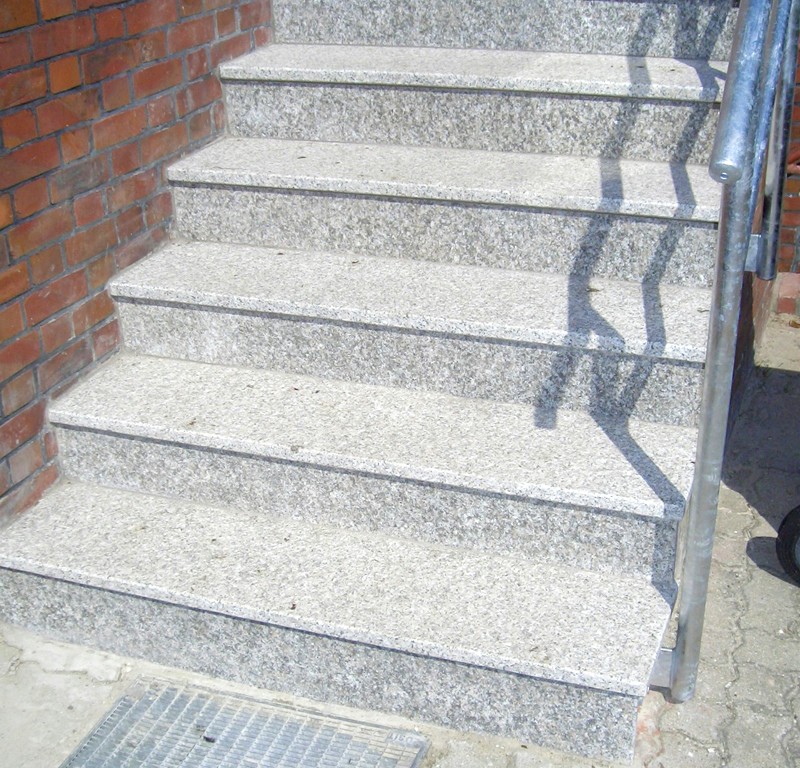 Eine einfache Treppe aus Natursteinplatten an einem Haus