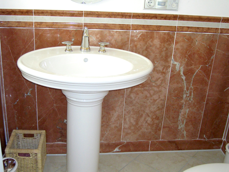 Ein rundes Waschbecken an einer beige braunen Wand